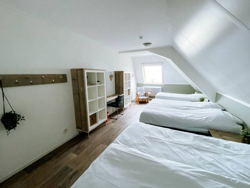 Slaapkamer met drie bedden.