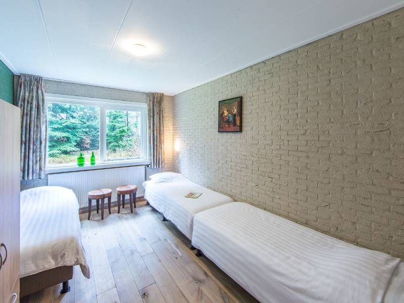 Een kamer met drie bedden.