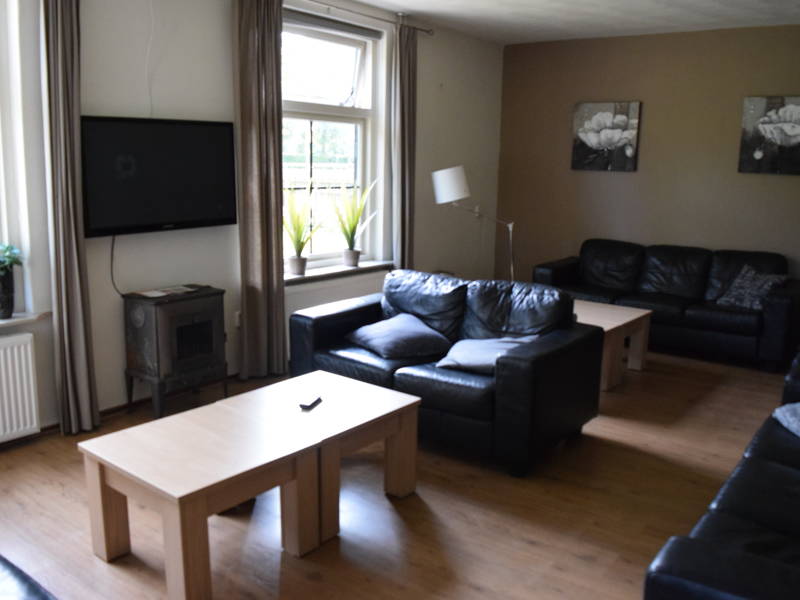 Een fraaie huiskamer met een tv.