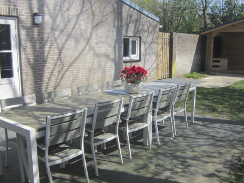 Een tafel buiten met terrasstoelen.