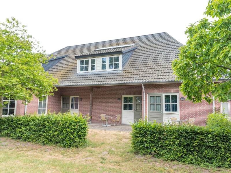 De zijkant van het verblijf met een terras.