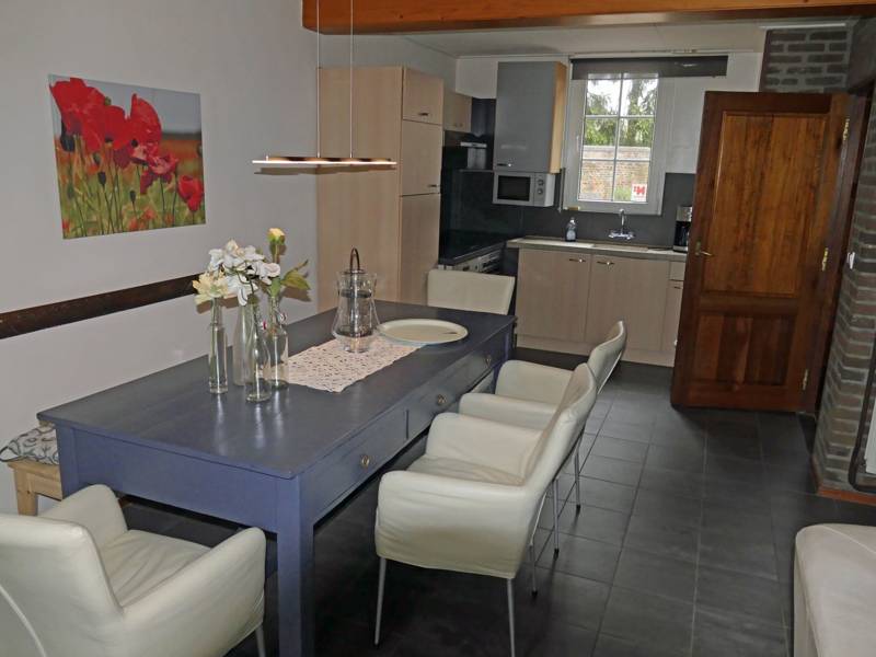 Woonkamer met eettafel en keuken op de achtergrond groepsaccommodatie Eijsden 6 personen